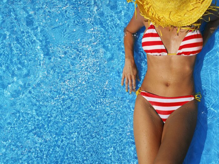 woman relaxing in a pool wearing a sun hat sun damage Med Spa in Medford New Jersey