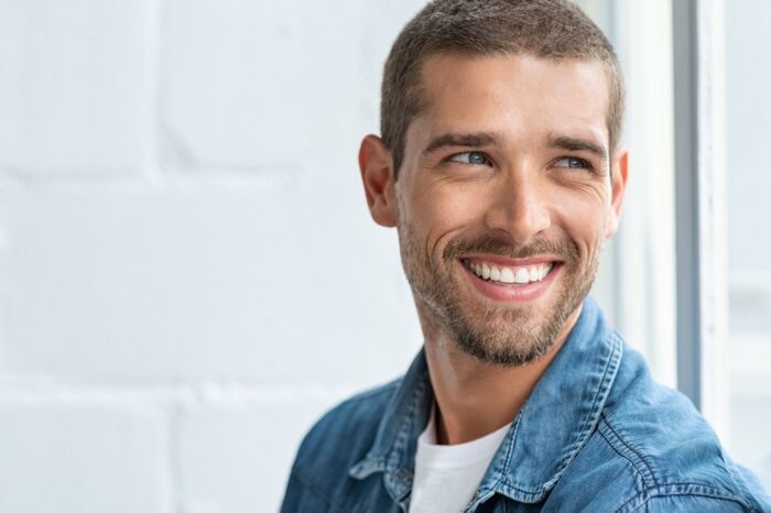 Confident young man looking away with big smile cosmetic procedures MedSpa in Hamilton New Jersey